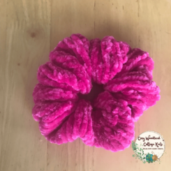 a bright pink velvet scrunchie