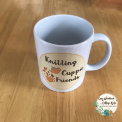 a knitting mug with a yellow oval. Inside the oval is the words "knitting cuppa friends" and a teapot pouring into a mug