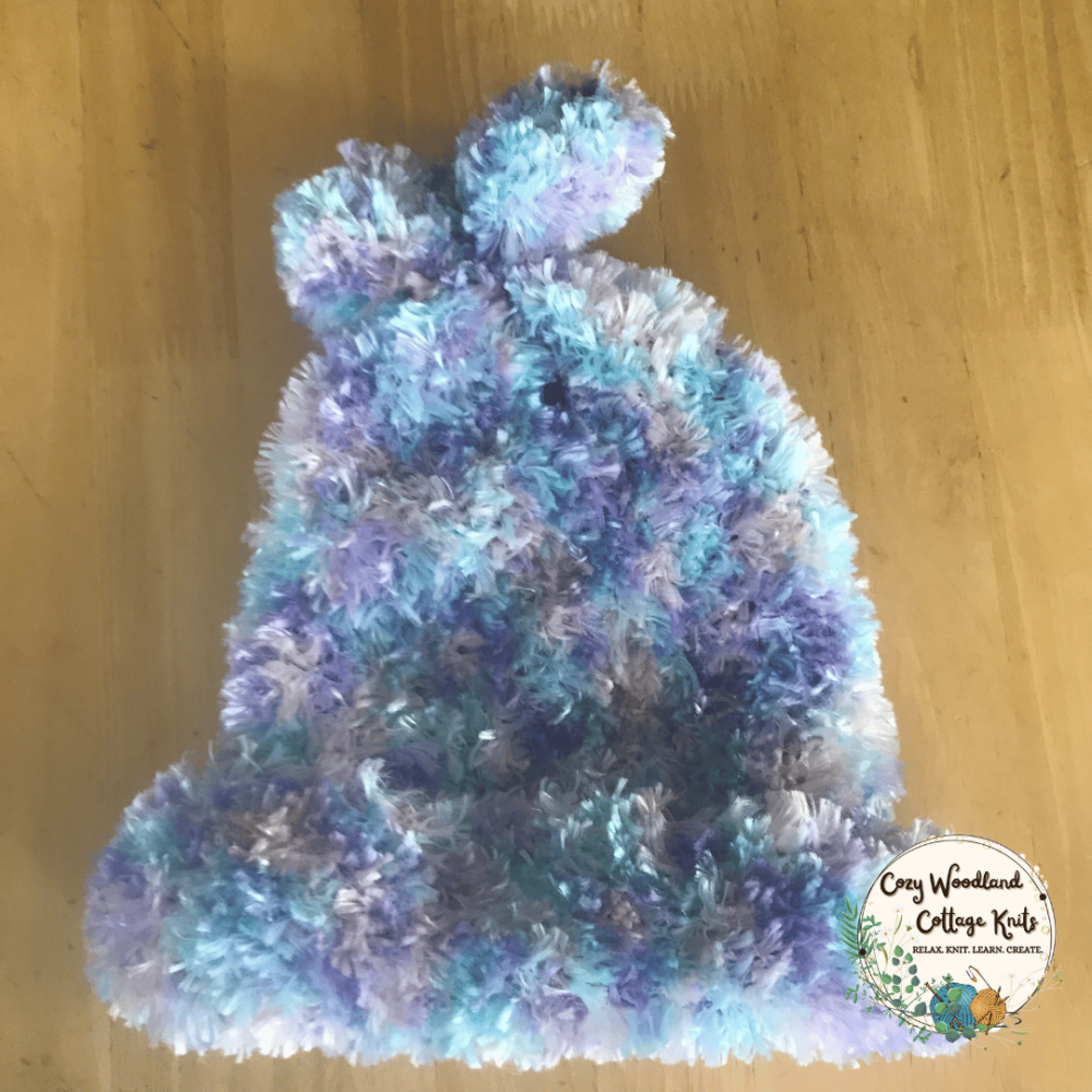 a teenagers slouchy beanie knitted with feathered yarn