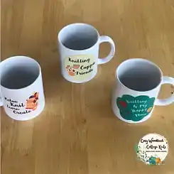Three knitting mugs on a wooden table.
