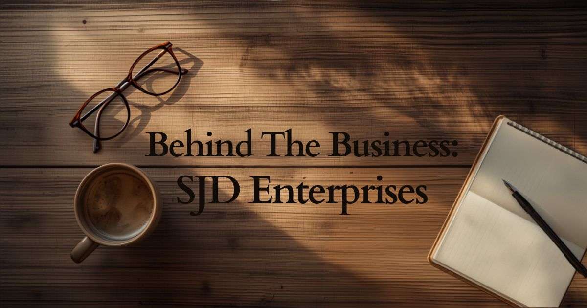 A flat-lay photograph featuring an open notebook and pen on a rustic table, representing the Behind the Business series featuring SJD Enterprises, a New Zealand small business.